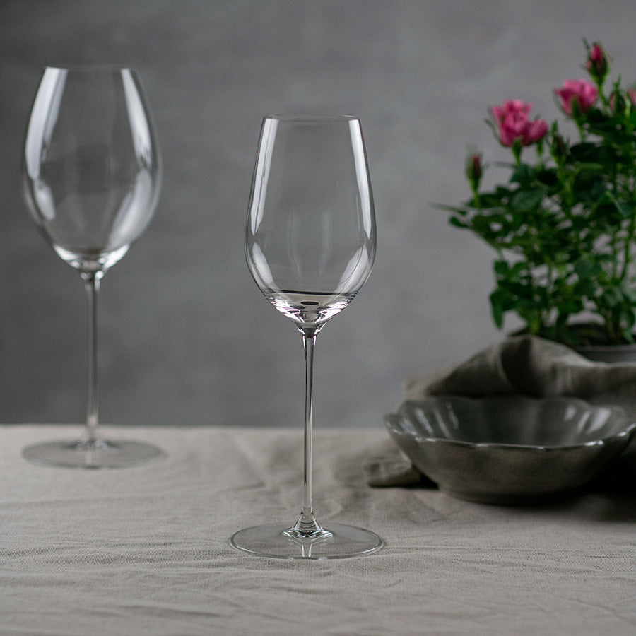 To Riedel Superleggero allroundglass på et dekket bord, med fokus på deres slanke design og stilk, passer til en rekke viner.