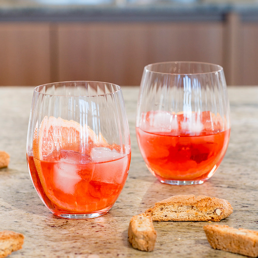 To Riedel longdrinkglass fylt med iskald cocktail og snacks, ideelt for festlige anledninger.