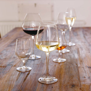 Hadeland Glassverk Odyssé rødvinsglass 82cl i et assortert sett av seks glass, plassert på et rustikt bord. Perfekt for servering av rødvin, hvitvin og dessertvin.