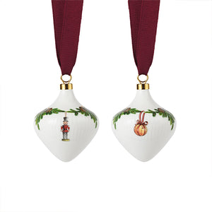 Royal Copenhagen juletrepynt i porselen, sett med to ornamenter dekorert med grangirlandermønster og rødt bånd.