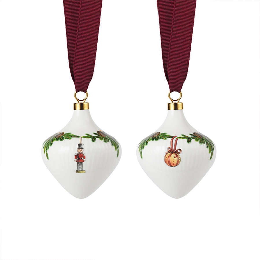 Royal Copenhagen juletrepynt i porselen, sett med to ornamenter dekorert med grangirlandermønster og rødt bånd.