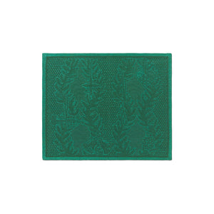 Detaljert bilde av en bordbrikke fra Royal Copenhagen i dyp grønn farge, med jacquardvevd mønster og subtile julemotiver, ideell for å skape julestemning.