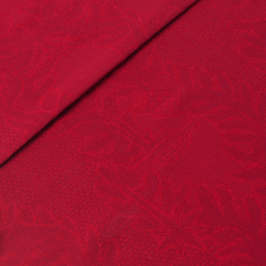 Detalj av rød juleduk med mønster av hjerter og stjerner, laget av bomull og lin.