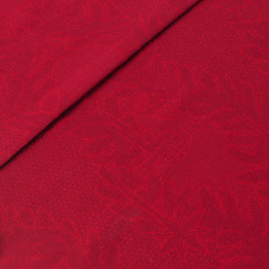 Detalj av rød juleduk med mønster av hjerter og stjerner, laget av bomull og lin.