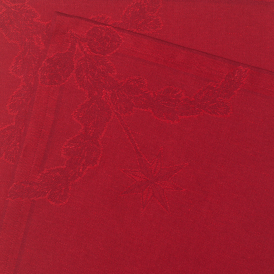 Detalj av en rød stoffserviett fra Royal Copenhagen, med jacquardvevd mønster av hjerte og stjerne, ideell for å skape en festlig atmosfære.