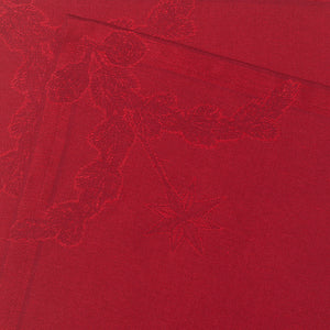 Detalj av en rød stoffserviett fra Royal Copenhagen, med jacquardvevd mønster av hjerte og stjerne, ideell for å skape en festlig atmosfære.