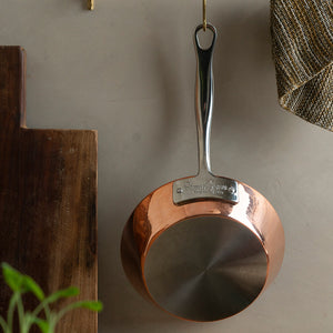 Samuel Groves stekepanne henger dekorativt på veggen, fremhever den elegante kobberdesignen.