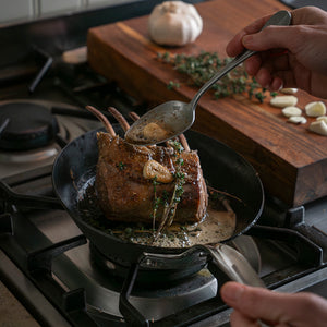 En stekepanne i karbonstål fra Samuel Groves som viser steking av kjøtt, perfekt til grilling og sautering.