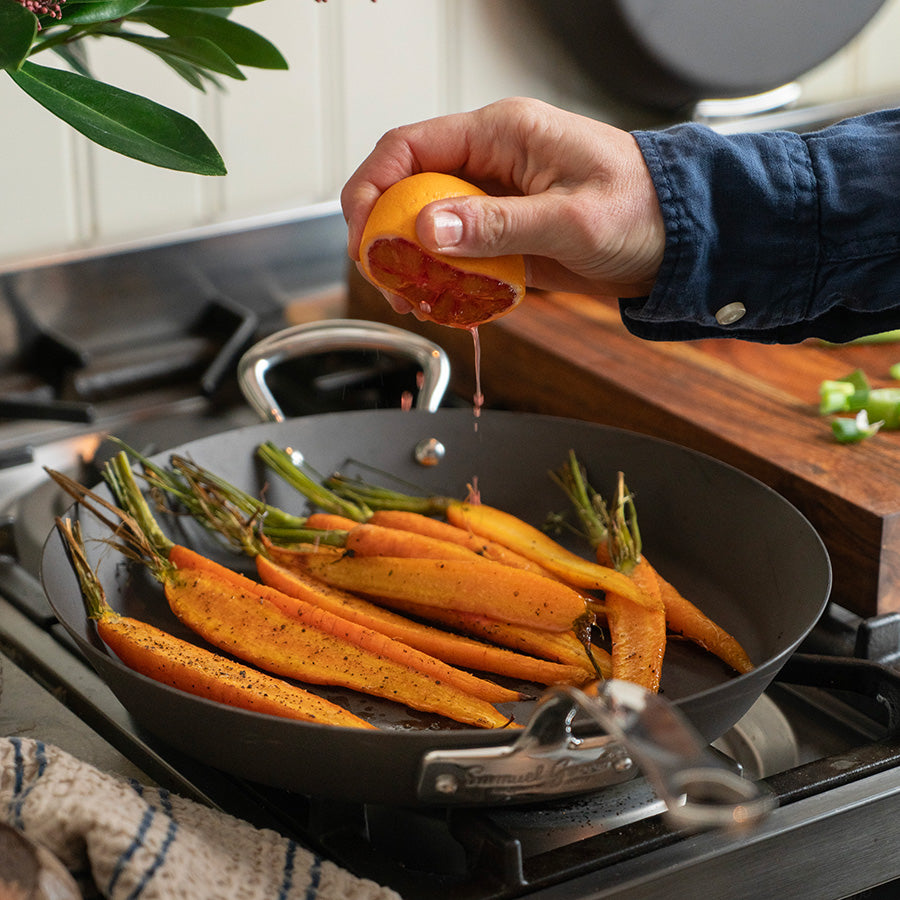 Frisk tilberedning med Samuel Groves stekepanne, der noen deilige gulerøtter stekes og saft presses over, ideell for sunn matlaging.