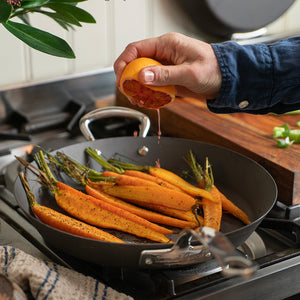 Frisk tilberedning med Samuel Groves stekepanne, der noen deilige gulerøtter stekes og saft presses over, ideell for sunn matlaging.