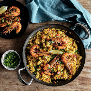 Samuel Groves Sautépanne Karbonstål 30cm fylt med risrett og reker, serveres med friske urter og sitron.