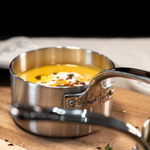 Minikasserolle fra Samuel Groves med kremet suppe, på trebrett, illustrerer stilfull servering av småretter.