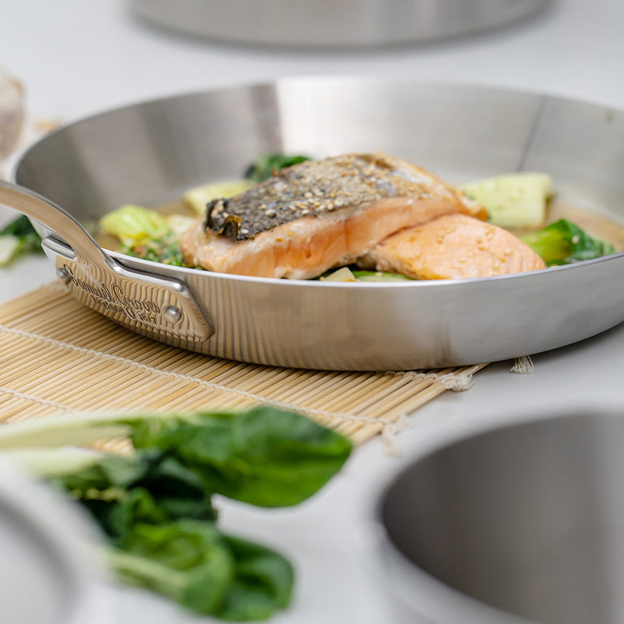 Stekepanne med laks og grønnsaker, ideell for å oppnå en naturlig stekeskorpe.