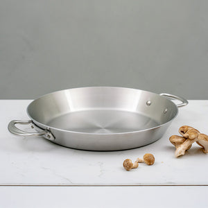 Rustfritt stål sautépanne fra Samuel Groves på et steinbord, med sopp ved siden av for matlaging.