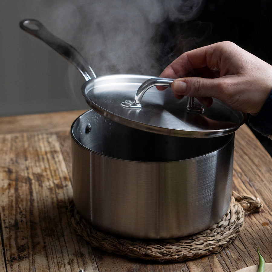 Kasserolle med lokk og damp som stiger opp, brukt på kjøkkenet til effektiv matlaging. Samuel Groves design.