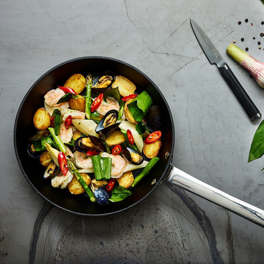 Scanpan stekepanne med grønnsaks- og sjømatrett, demonstrerer non-stick overflate og stilrend design.