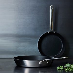 Scanpan stekepanner i rustfritt stål, en størrelse på 20 cm, en størrelse på 28 cm, elegant plassert mot en grå bakgrunn.