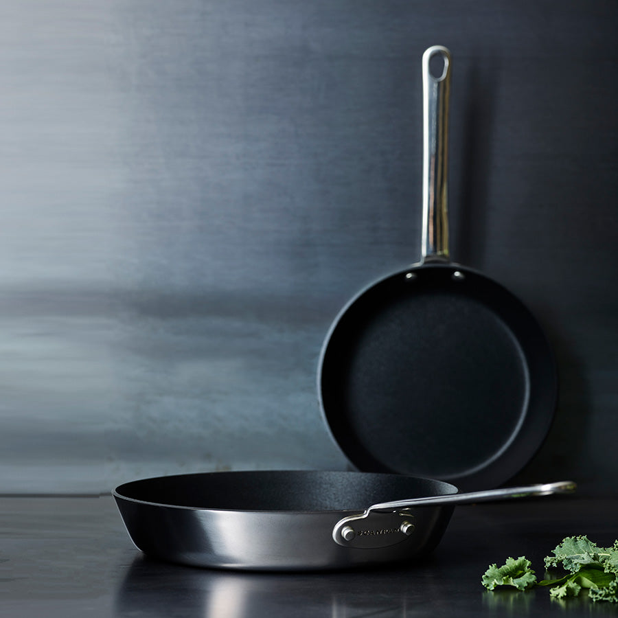 Scanpan stekepanner i rustfritt stål, en størrelse på 20 cm, en størrelse på 28 cm, elegant plassert mot en grå bakgrunn.