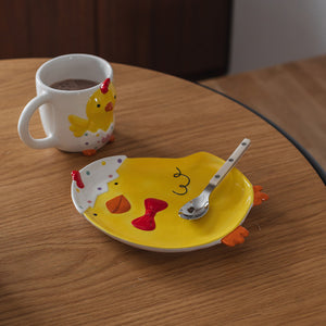 Koselig frokostoppsett med påskekylling asjett og kopp, ideelt for å skape en glad atmosfære til påskefrokosten.