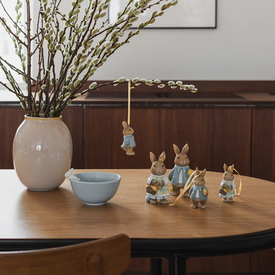 Koselig påskepynt med flere haremor, plassert ved en vase med påskepynt, skaper en lun atmosfære.