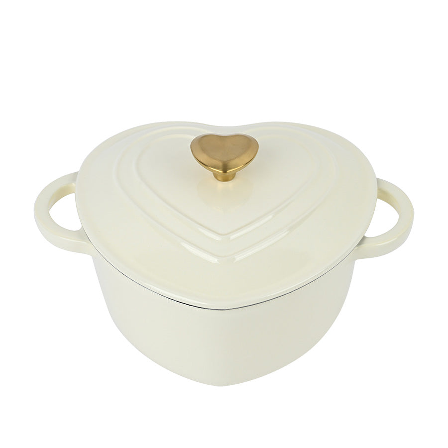 Romantisk hjerteformet støpejernsgryte med kremfarget finish og gullknott, perfekt for matlaging og borddekking.