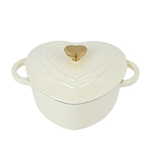 Romantisk hjerteformet støpejernsgryte med kremfarget finish og gullknott, perfekt for matlaging og borddekking.
