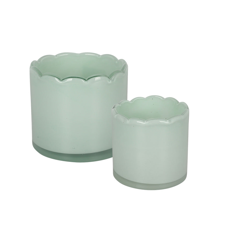 Sett med to lyslykter i lys grønn glass, 8 cm og 11 cm høye, med dekorativ bølgekant. Perfekt for å skape lys og stemning i hjemmet.