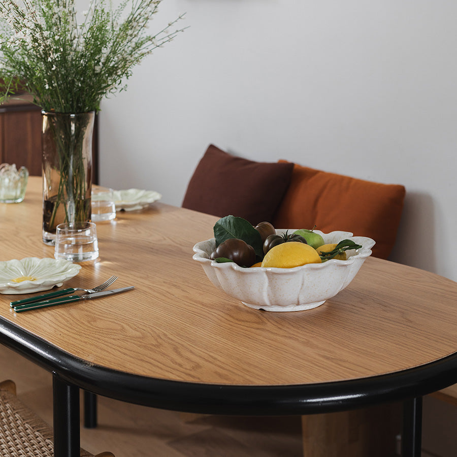 Blomsterformet serveringsbolle fylt med frukt, presentert på et elegant bord i moderne innredning.