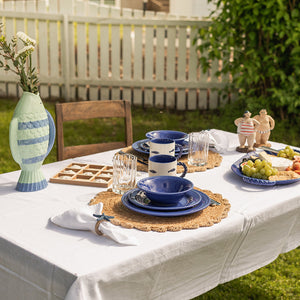 Borddekk med marineblå tallerken fra Seasons Summer Collection, med dekorative elementer og delikate retter, perfekt for en vennlig sommerlunsj.