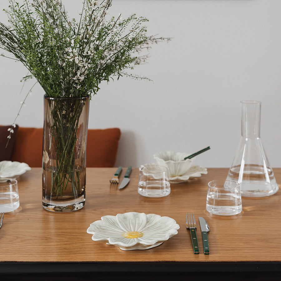 Seasons Spring Collection blomsterformet tallerken 21cm Grønn brukt på et bord med blomsterbukett, glass og bestikk, viser en innbydende borddekking.