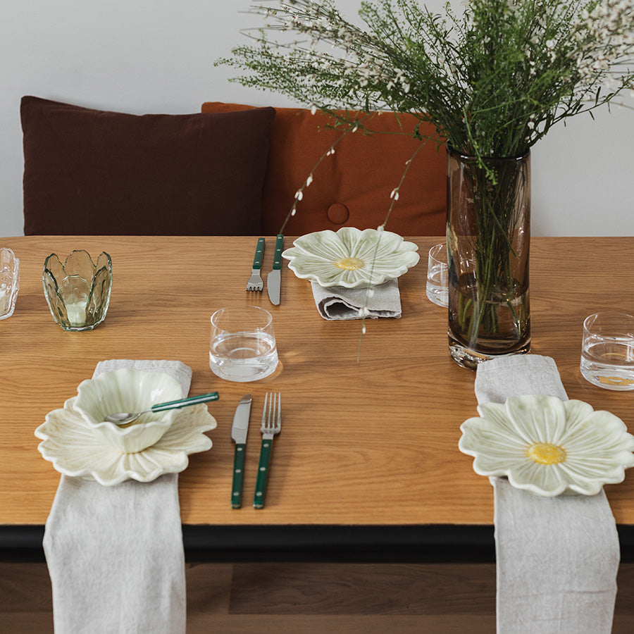 Seasons Spring Collection blomsterformet tallerken 21cm Grønn på et pent dekket bord med servietter og bestikk, gir et friskt vårpreg.