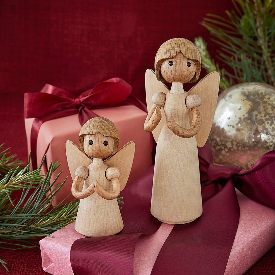 To Spring Copenhagen Aura Trefigur i julerødt miljø med gaver, som fremhever sesongens hjertevarme.