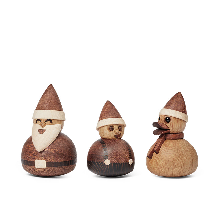 En samling av tre figurer, inkludert en duckie, julenisse og en liten gutt, alle med julehatter, laget av FSC-sertifiserte materialer.