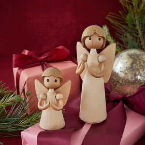 Spring Copenhagen Gloria Trefigur - to trefigurer plassert blant julegaver og dekorasjoner, fremkaller en fredelig julestemning.