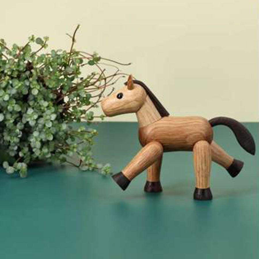 SPRING COPENHAGEN Spring Copenhagen Wooden Figures Comet – dekorativ liten trehestfigur som Comet i interiørmiljø med grønn vase/planter
