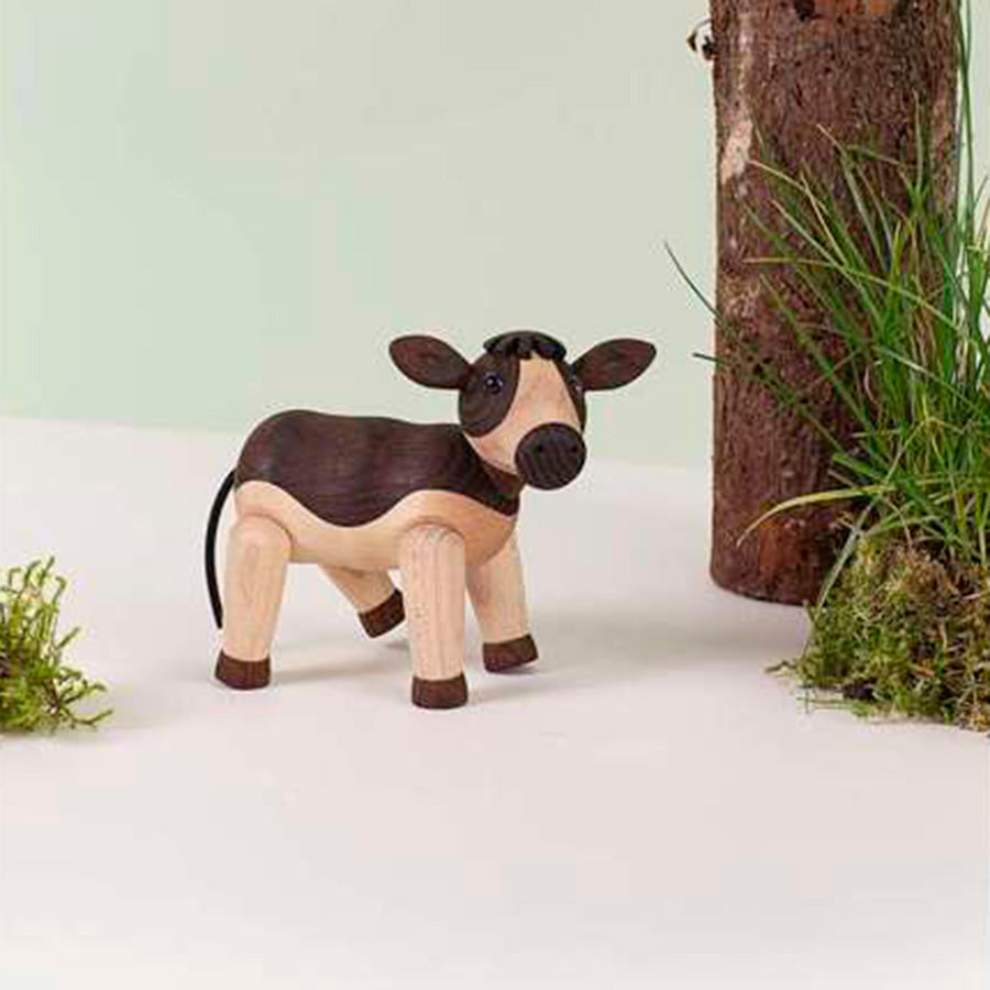 SPRING COPENHAGEN Spring Copenhagen Wooden Figures Dandy – Dandy trefigur av ku-kalv i bondegårdsstil ved liten pott med gress