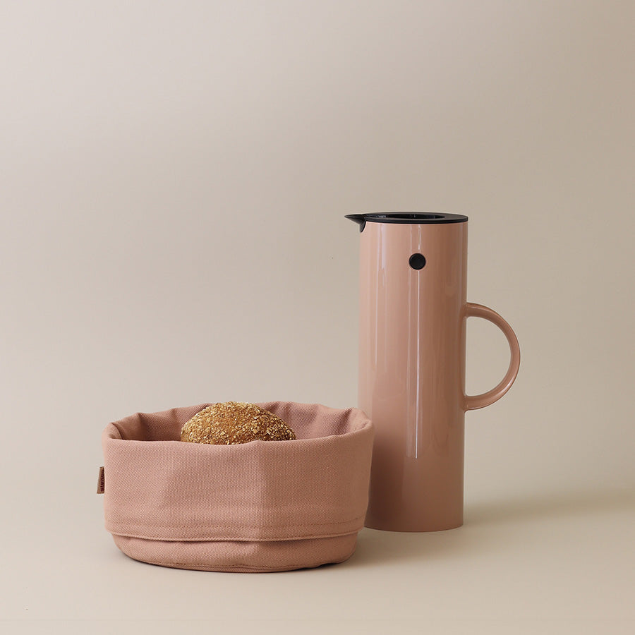 Stelton EM77 termokanne i heather sammen med en brødkurv, elegant bordssetting.