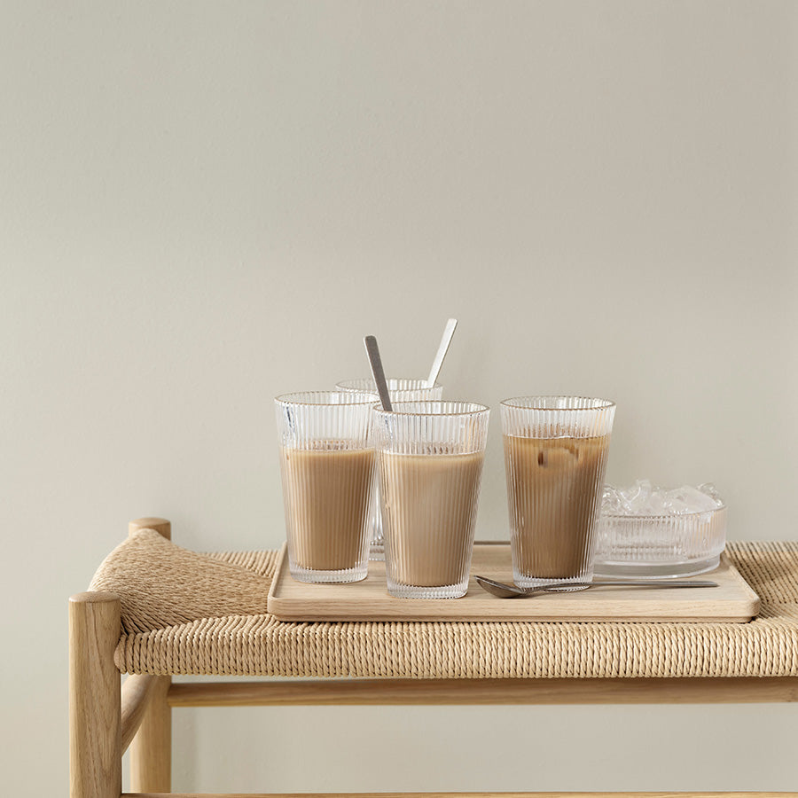 Tre drikkeglass med kaffe latte og isbiter på et bord, ideelt for alle anledninger, ansett som drikkeglass.