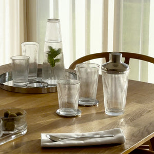 Et elegant oppsett med drikkeglass, shaker og serveringsbrett, fremhever allsidigheten til drikkeglass i hverdagen.