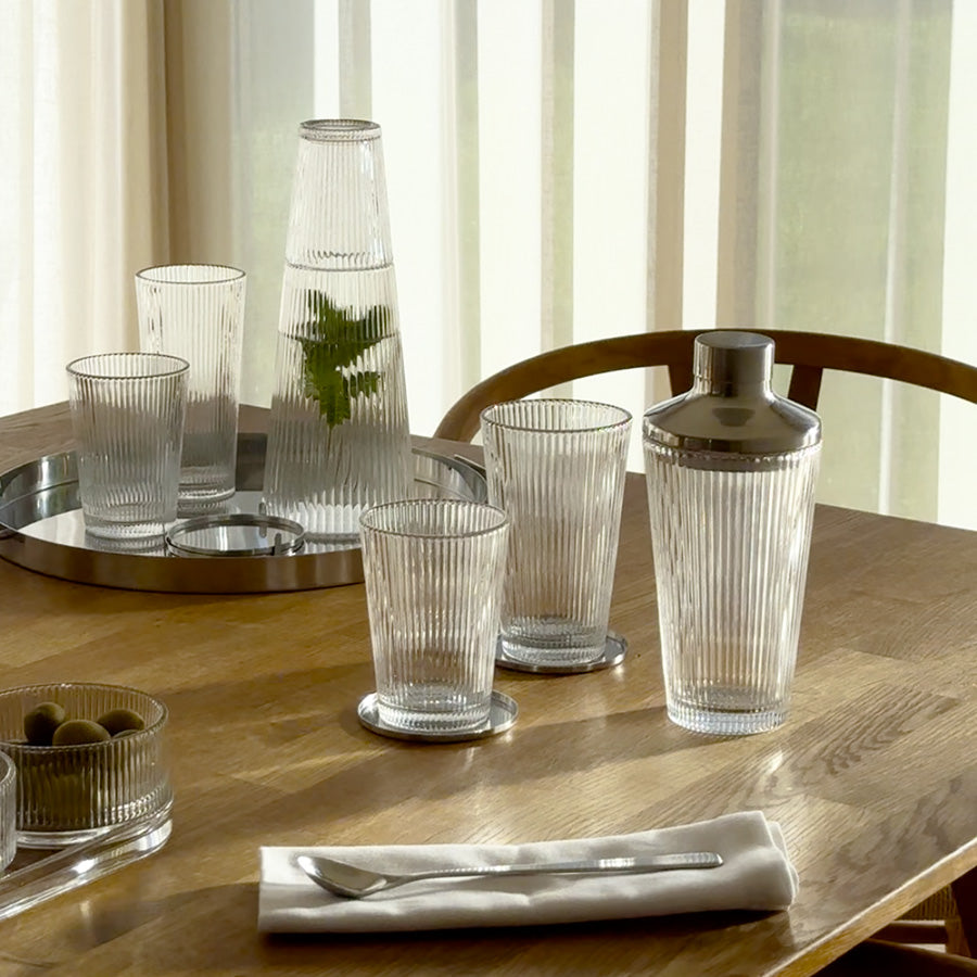 Et elegant oppsett med drikkeglass, shaker og serveringsbrett, fremhever allsidigheten til drikkeglass i hverdagen.