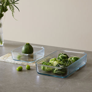 To Stelton ildfast former på et bord, fylt med grønnsaker, ideelle for moderne kjøkken og servering.