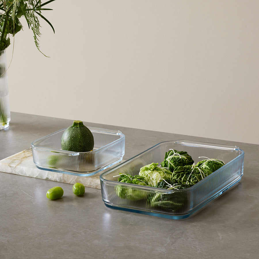 To Stelton ildfast former på et bord, fylt med grønnsaker, ideelle for moderne kjøkken og servering.