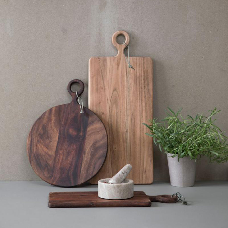 Skjærebrett i akasietre i forskjellige former, inkludert rundt og rektangulært, for stilfull servering.