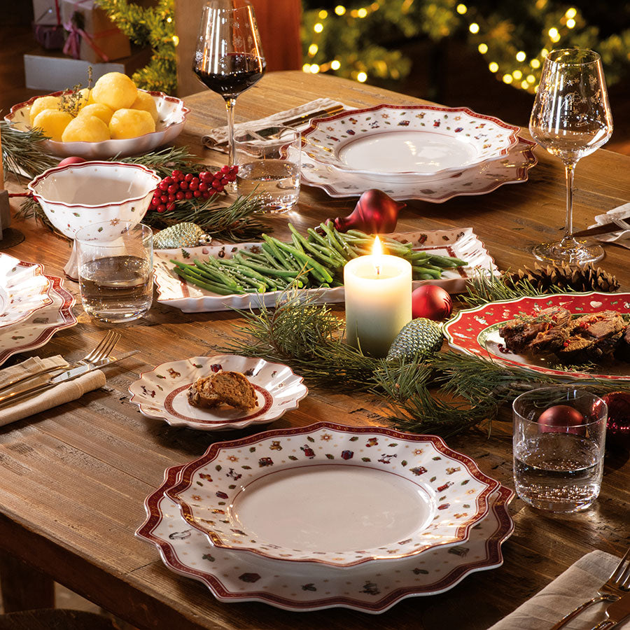 Villeroy & Boch Toy's Delight servise i en koselig julemiddagssituasjon, med tallerkener, glass og julepynt på et lyst bord.