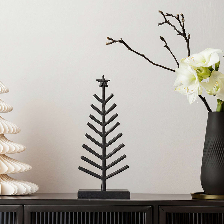 Stilrent sort juletre fra Villeroy & Boch på skjenk, dekorert med hvite blomster