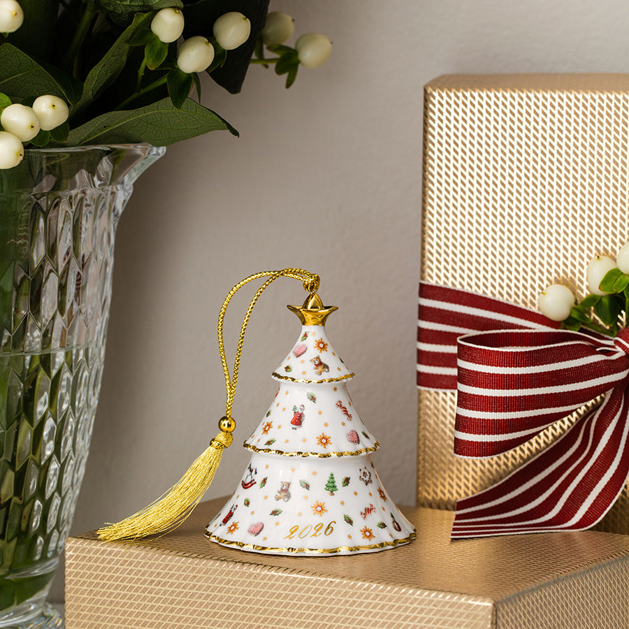 Julepynt fra Villeroy & Boch – Christmas Classics porselensjuletre 2026 dekorert med gull og plassert på innpakket gave