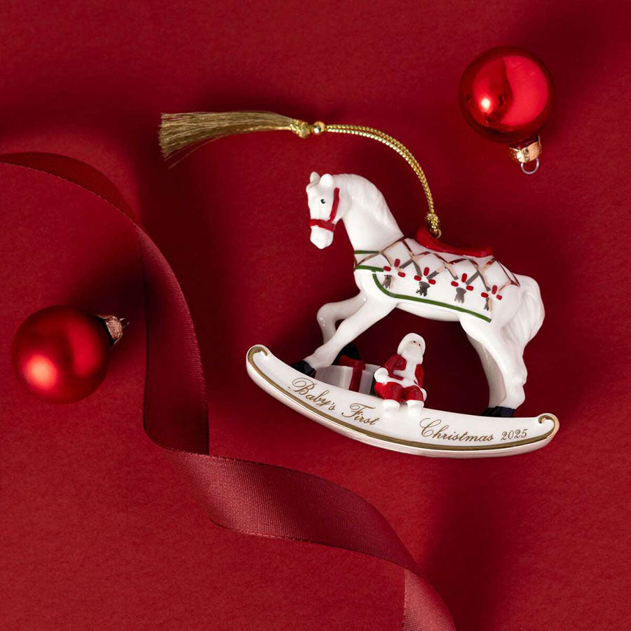 Villeroy & Boch gyngehest i porselen omgitt av julepynt, med inskripsjonen 'Baby’s First Christmas 2025', festlig dekorasjon.