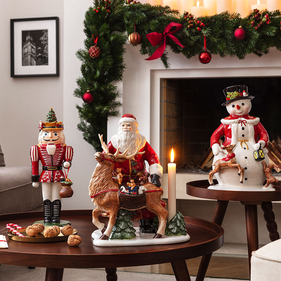 Villeroy & Boch julenisse med reinsdyr og nutcracker i et julepyntet rom med peis og dekorasjoner.