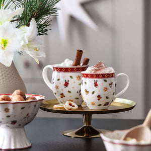 To Villeroy & Boch julekopper fylt med kakao og pyntet med kanelstenger, perfekt for julefeiring.