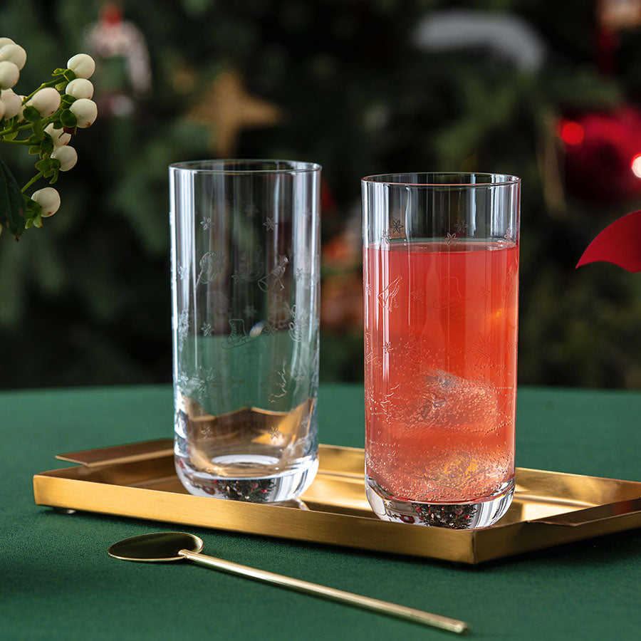 To Villeroy & Boch longdrinkglass fylt med julecocktails, plassert på en gyllen brett, ideelle for festbordet.
